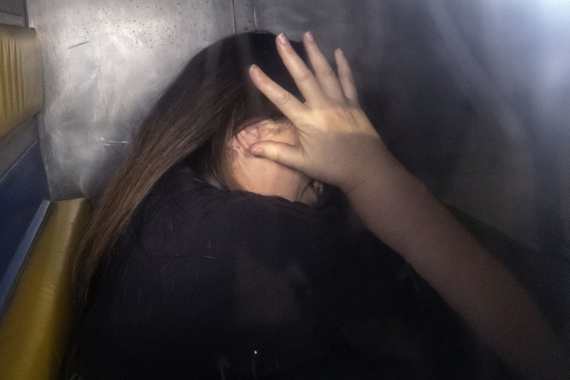 Erin Patterson, convicted triple murderer, shielding her face from the camera.