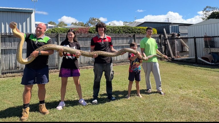 Jay Everding and his children show off the 5.2m python. 