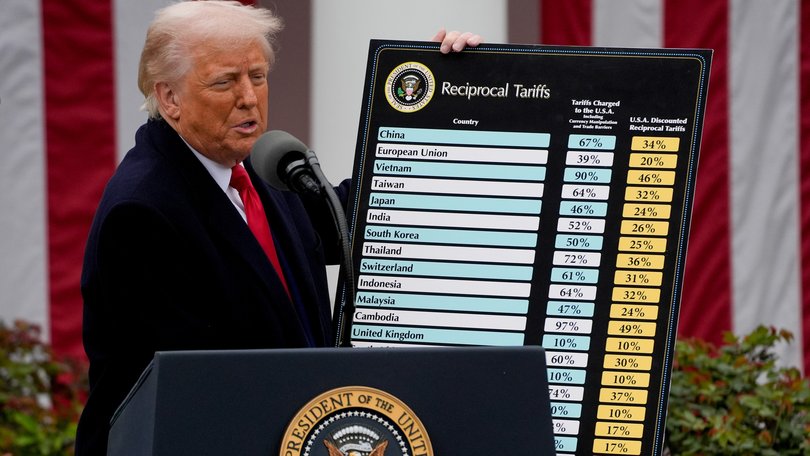 US President Donald Trump holds a reciprocal tariffs poster during a tariff announcement in the Rose Garden of the White House in Washington, DC, US, on Wednesday, April 2, 2025.