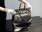 An auction officer displays the original Birkin bag created by Hermès for Jane Birkin in 1984, prior to its auction Thursday, July 10, 2025 in Paris. (AP Photo/Michel Euler) Michel Euler