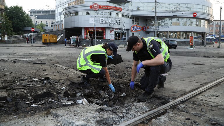Police  collect remains of a Russian explosive device on the road after a Russian drones and missiles attack on Thursday in Kyiv.