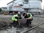 Police  collect remains of a Russian explosive device on the road after a Russian drones and missiles attack on Thursday in Kyiv.