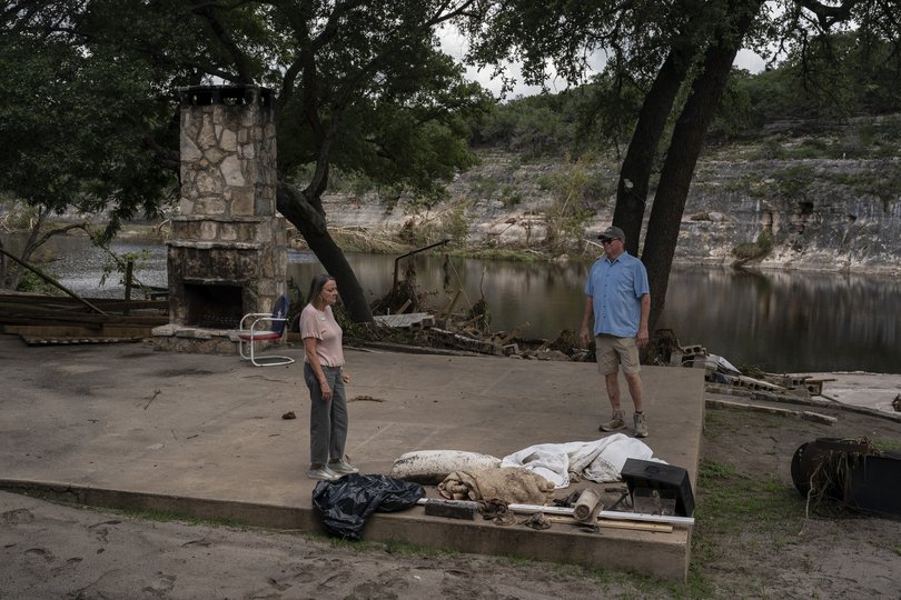 Scott Towery and his wife Connie survey what remained of an outdoor seating at a resort on a small rise along the Guadalupe River in Hunt, Texas.