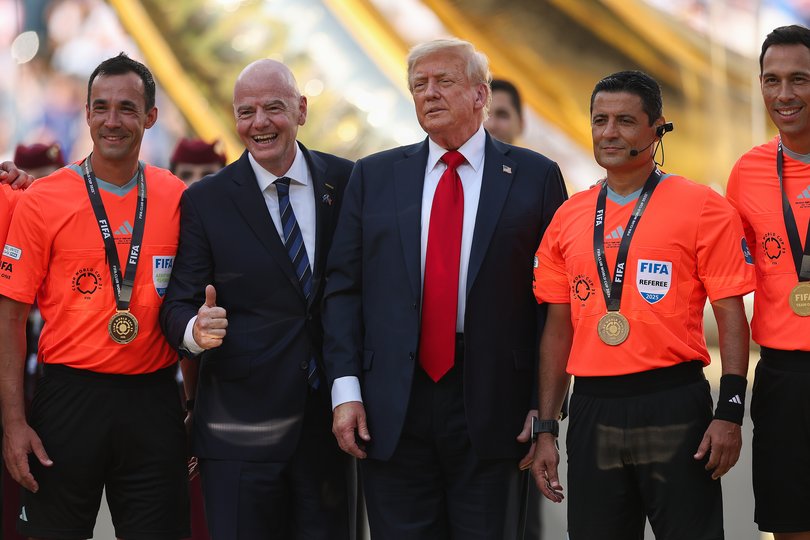 Gianni Infantino and Donald Trump pose for a photo with video match officials and referees.