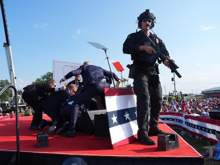 Secret Service agents cover Republican presidential nominee Donald Trump after shots were fired during a campaign rally on July 13, 2024, in Butler, Pennsylvania. MUST CREDIT: Jabin Botsford/The Washington Post