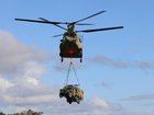 An Australian Army CH-47F Chinook helicopter lifts a Mercedes-Benz G-Wagon as an underslung load from Shoalwater Bay training area during Exercise Talisman Sabre 2025. CAPT Joanne Leca