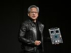 Jensen Huang, co-founder and chief executive officer of Nvidia Corp., holds up the company's AI accelerator chips for data centers as he speaks during the Nvidia AI Summit Japan in Tokyo  last year.