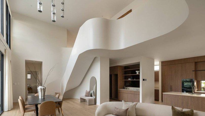 The white sculptural staircase becomes an architectural feature in the home.