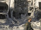 A soldier passes in front the damaged Syrian Defence Ministry building which was hit by several Israeli airstrikes, in Damascus.
