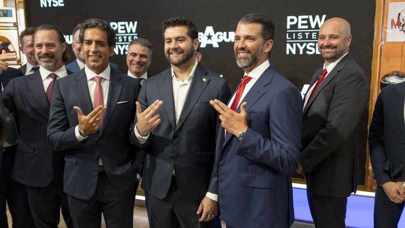Investment banker Omeed Malik (2-L), Marc Nemati, CEO of GrabAGun (4-L), and Donald Trump Jr. (2-R) pose while holding their hands in the shape of guns at the New York Stock Exchange.
