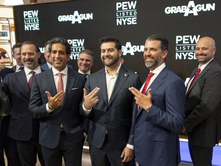 Investment banker Omeed Malik (2-L), Marc Nemati, CEO of GrabAGun (4-L), and Donald Trump Jr. (2-R) pose while holding their hands in the shape of guns at the New York Stock Exchange.