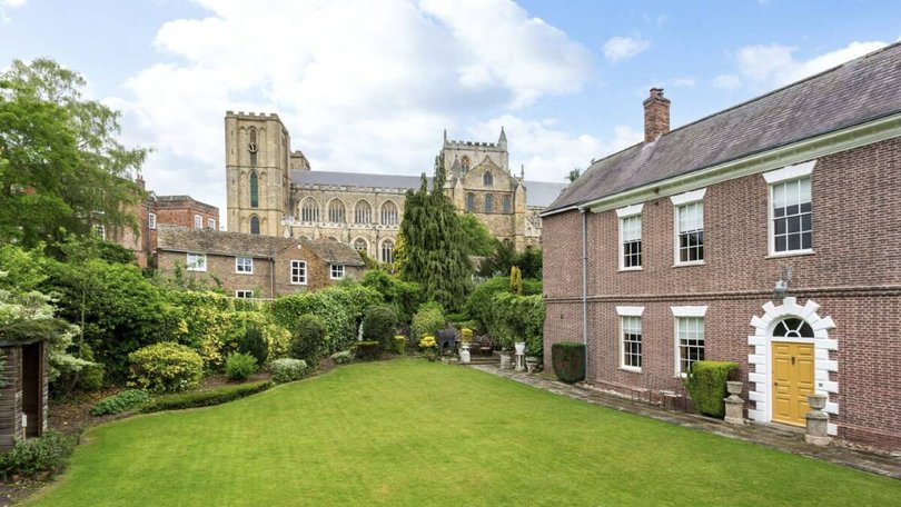 The private walled gardens lead onto a manicured lawn.