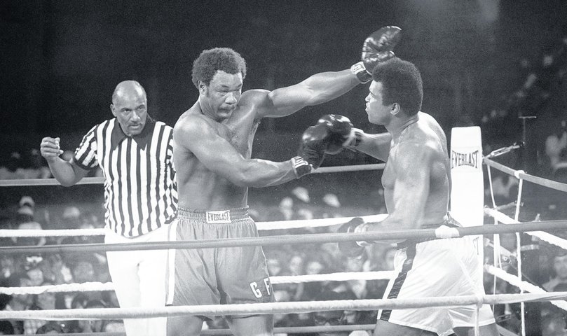 Heavyweight champ George Foreman (L), throws a left to the eye of the Muhammed Ali during their title bout.