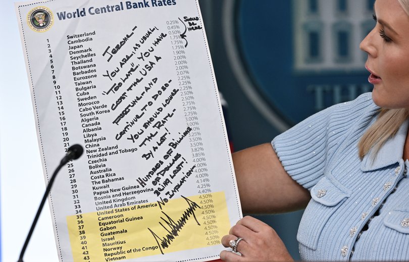 White House press secretary Karoline Leavitt holds up a handwritten note by President Donald Trump to Fed Chair Jerome H. Powell on lowering interest rates.