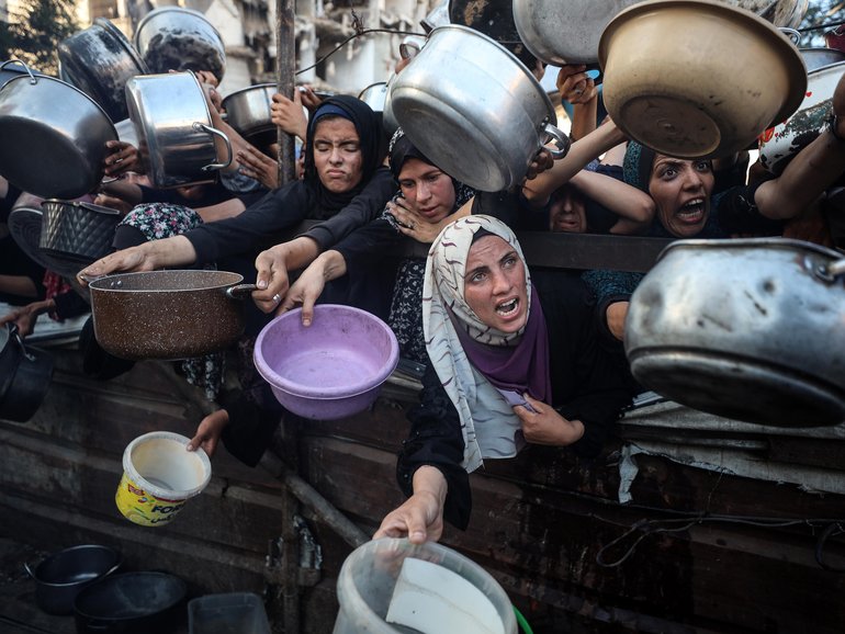 Palestinians gather at a food distribution point in Gaza City, on July 20.