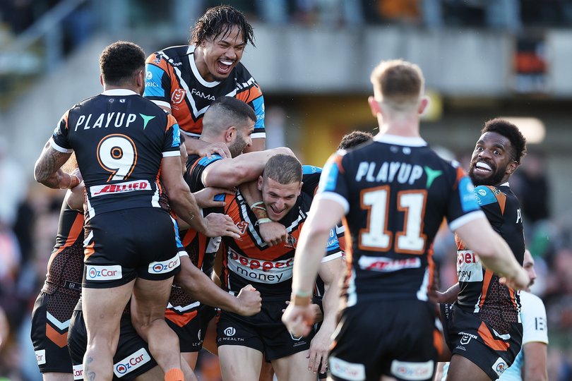 Adam Doueihi of the Tigers celebrates with team mates after kicking the match winning field goal.