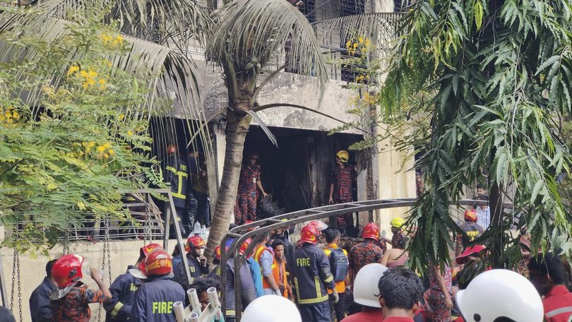 Firemen assess the wreckage of a Bangladesh Air Force training aircraft that crashed in Dhaka.