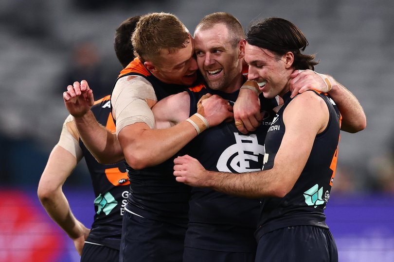 Patrick Cripps, Sam Docherty and Oliver Hollands of the Blues celebrate a goal against Melbourne.