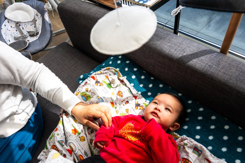 Julie Kang and Roshan George play with their baby in their home in San Francisco. MUST CREDIT: Camille Cohen/For The Washington Post