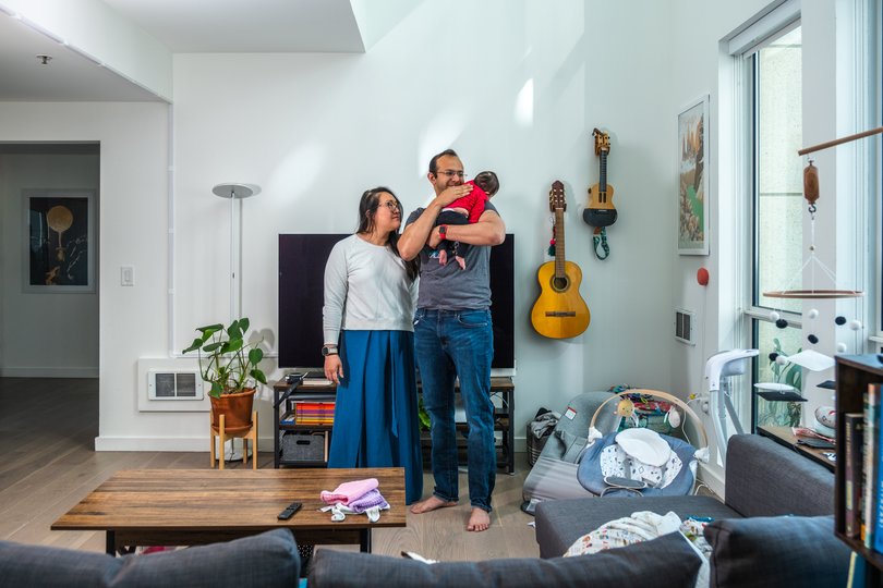 Julie Kang and Roshan George with their 3-month-old baby, Astra Meridian, in their home in San Francisco in late May. MUST CREDIT: Camille Cohen/For The Washington Post