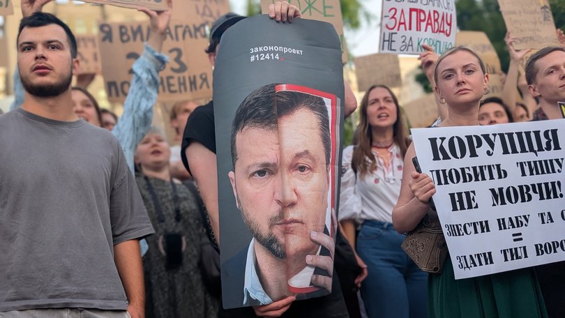 A protester in Kyiv holds a poster likening Ukraine’s President Volodymyr Zelensky to former president Viktor Yanukovych, who was ousted after the 2014 protests called the Revolution of Dignity.