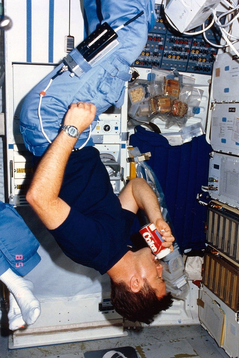Astronaut Tony England trying a sip of Coca-Cola aboard the Space Shuttle Challenger in 1985.