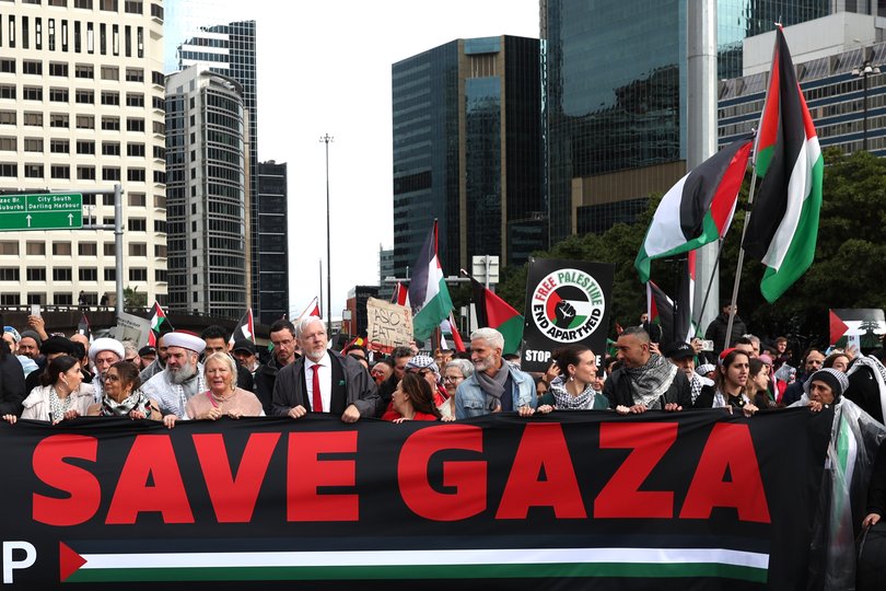 People, including Wikileaks founder Julian Assange (L), march towards the Harbour Bridge during the pro-Palestinian rally in Sydney.
