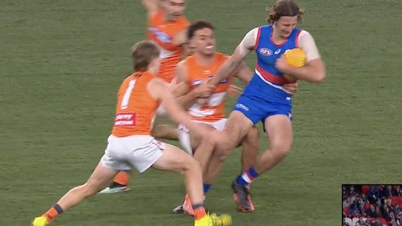 Young Bulldog key defender Jedd Busslinger being tackled by GWS Giant Jake Riccardi.