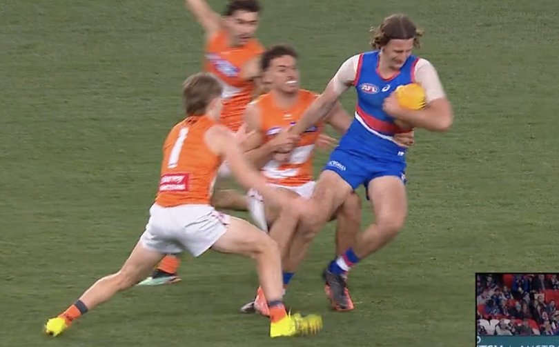 Young Bulldog key defender Jedd Busslinger being tackled by GWS Giant Jake Riccardi.