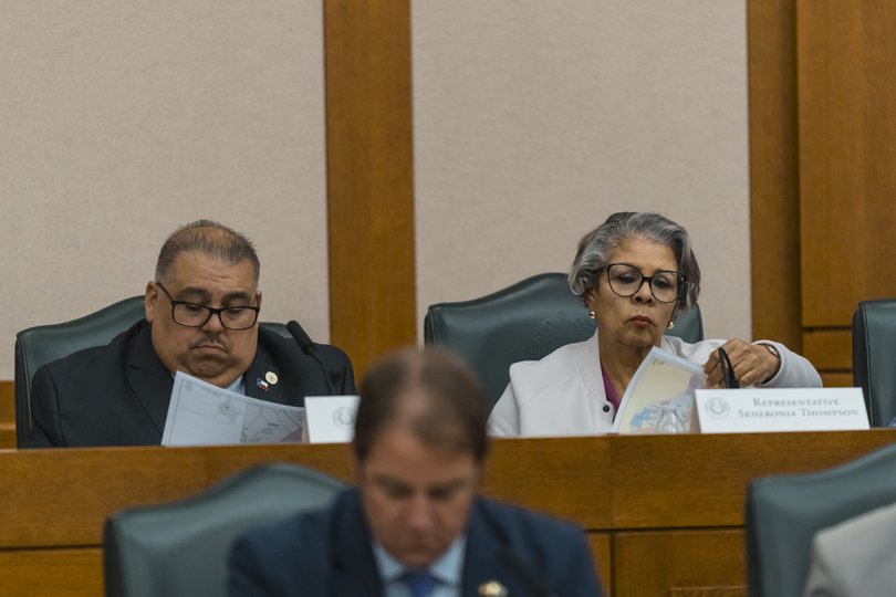 Texas state representatives review proposed maps before a hearing on redistricting in Austin, Texas, July 24, 2025.