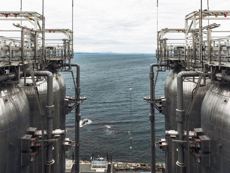 Tanks that hold thousands of tons of liquid carbon dioxide extracted from the exhaust produced by a cement plant in Oygarden, near the port city of Bergen, Norway, June 30, 2025. A business called Northern Lights is seen as a model for efforts to pump carbon dioxide deep into wells, but high costs remain an obstacle. (Thomas Ekstrm/The New York Times)