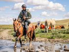 Brandon Fiore walks his horse through a stream.