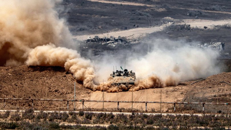 An Israeli army infantry-fighting vehicle (IFV) leaves a cloud of dust as it moves at a position along Israel's southern border with the Gaza Strip on August 5.