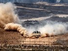 An Israeli army infantry-fighting vehicle (IFV) leaves a cloud of dust as it moves at a position along Israel's southern border with the Gaza Strip on August 5.