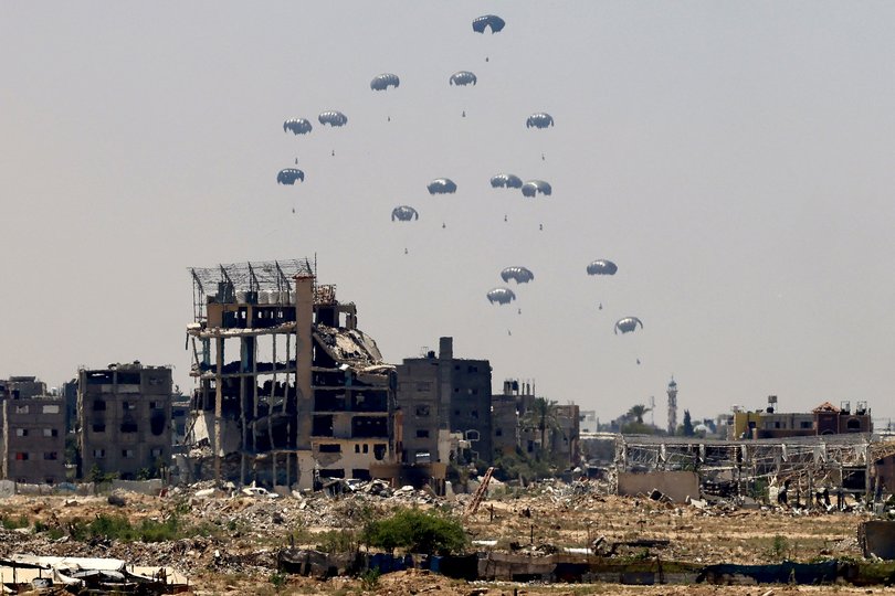 Aid pallets are parachuted after being dropped from a military plane over Nuseirat in the central Gaza Strip during an airdrop mission.