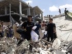 Palestinians rush to collect humanitarian aid that was dropped by parachute from planes flying over Gaza City on Thursday.