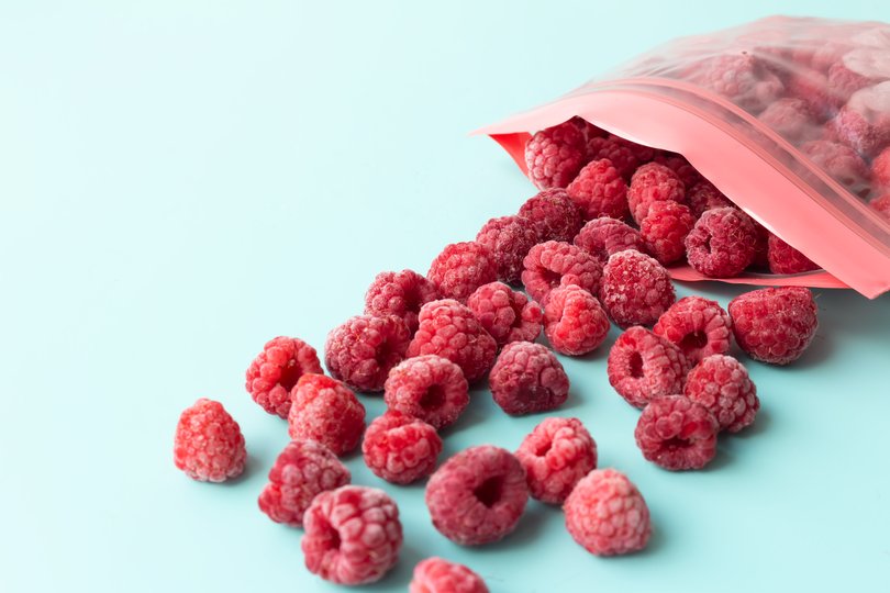 Frozen raspberries in a plastic bag with a fastener on a blue background. Preparations for the winter. Copy spase. Picture: 