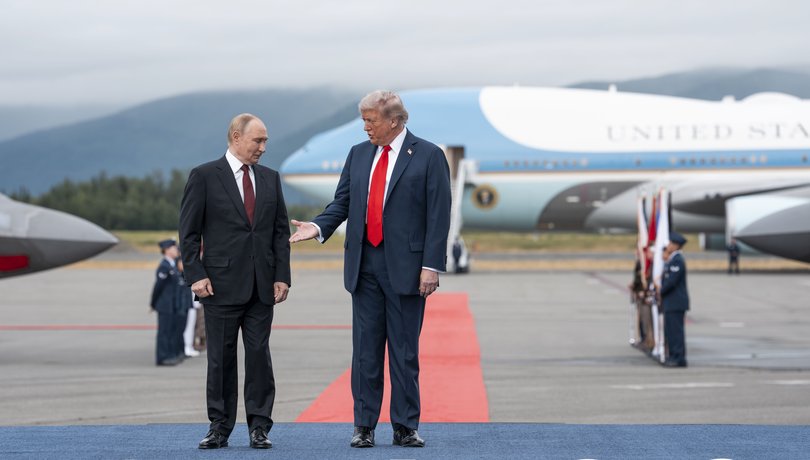 President Donald Trump reaches for a handshake with President Vladimir Putin of Russia as they meet at Joint Base Elmendorf-Richardson in Anchorage, Alaska.