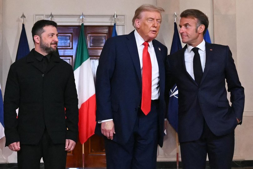 Ukrainian President Volodymyr Zelensky, US President Donald Trump, and French President Emmanuel Macron stand for a family photo with European leaders in the Cross Hall of the White House in Washington.
