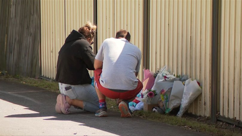 The family leave flowers at the scene.