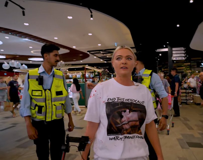 Tash Peterson is seen being arrested on Christmas Day after a protest where she poured fake blood over a glass display case of meat.