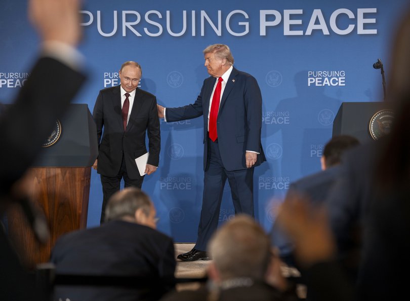 Russian President Vladimir Putin and President Donald Trump begin to leave the stage after making statements following their meeting in Alaska.