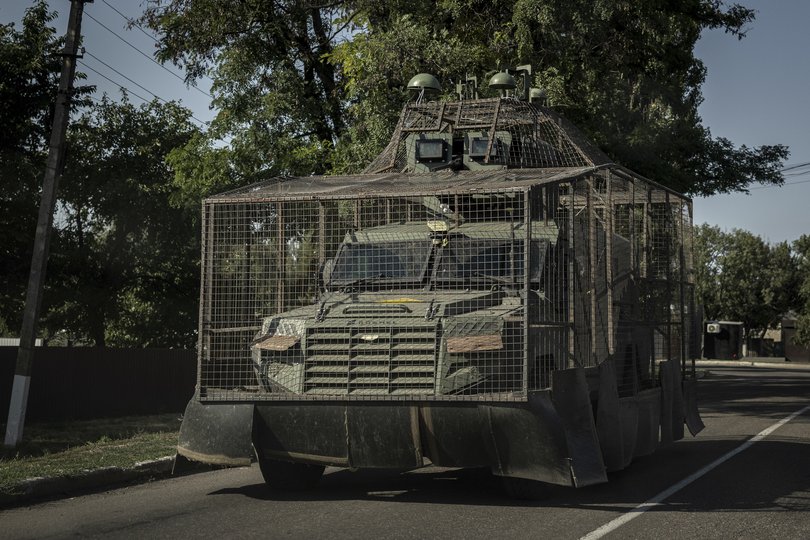 A Ukrainian Roshel Senator armored personnel carrier outfitted with a wire cage and electronic warfare domes to protect against drone attacks.