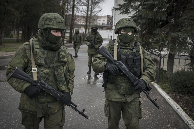 Armed men patrol the street outside Simferopol’s airport in the Crimea region of Ukraine.