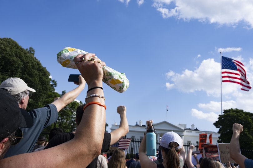 A protester holds up a sandwich during a “Fight the Trump Takeover” protest in front of the White House on August 16.