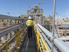 A worker walks across a bridge at the processing plant of the PLS Pilgangoora lithium project in Port Hedland.
