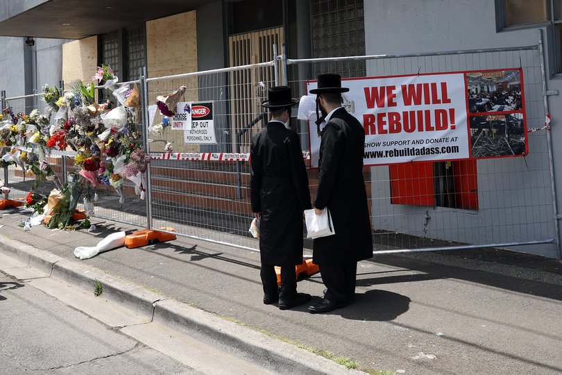 People gather outside the Adass Israel Synagogue after the firebombing in Melbourne.