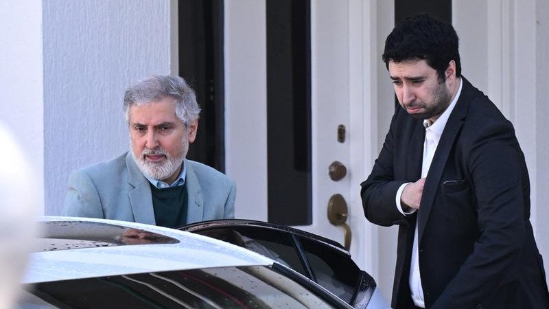 Iranian ambassador to Australia Ahmad Sadeghi (left) has been swept into a car, departing the embassy in Canberra.