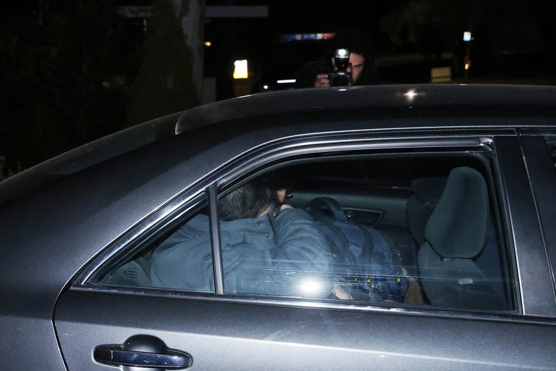 A car leaves the Iranian embassy premises in Canberra in the dark of night.