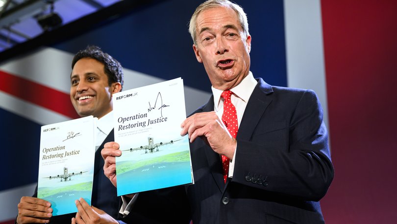Former Reform chairman Zia Yusuf and Reform UK Leader Nigel Farage, hold up signed copies of their new policy.